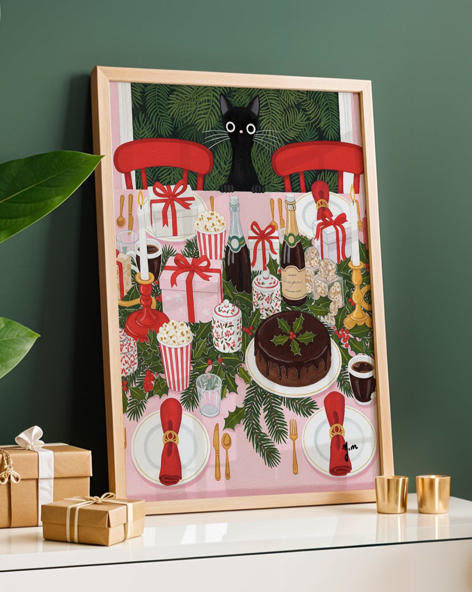  A vibrant and detailed art print depicting a black cat looking down from above onto a fully decorated Christmas dinner table. The table is set with red chairs white plates with red napkins silver cutlery bottles of champagne a chocolate cake with holly gifts candles and popcorn boxes all surrounded by green holly garlands.