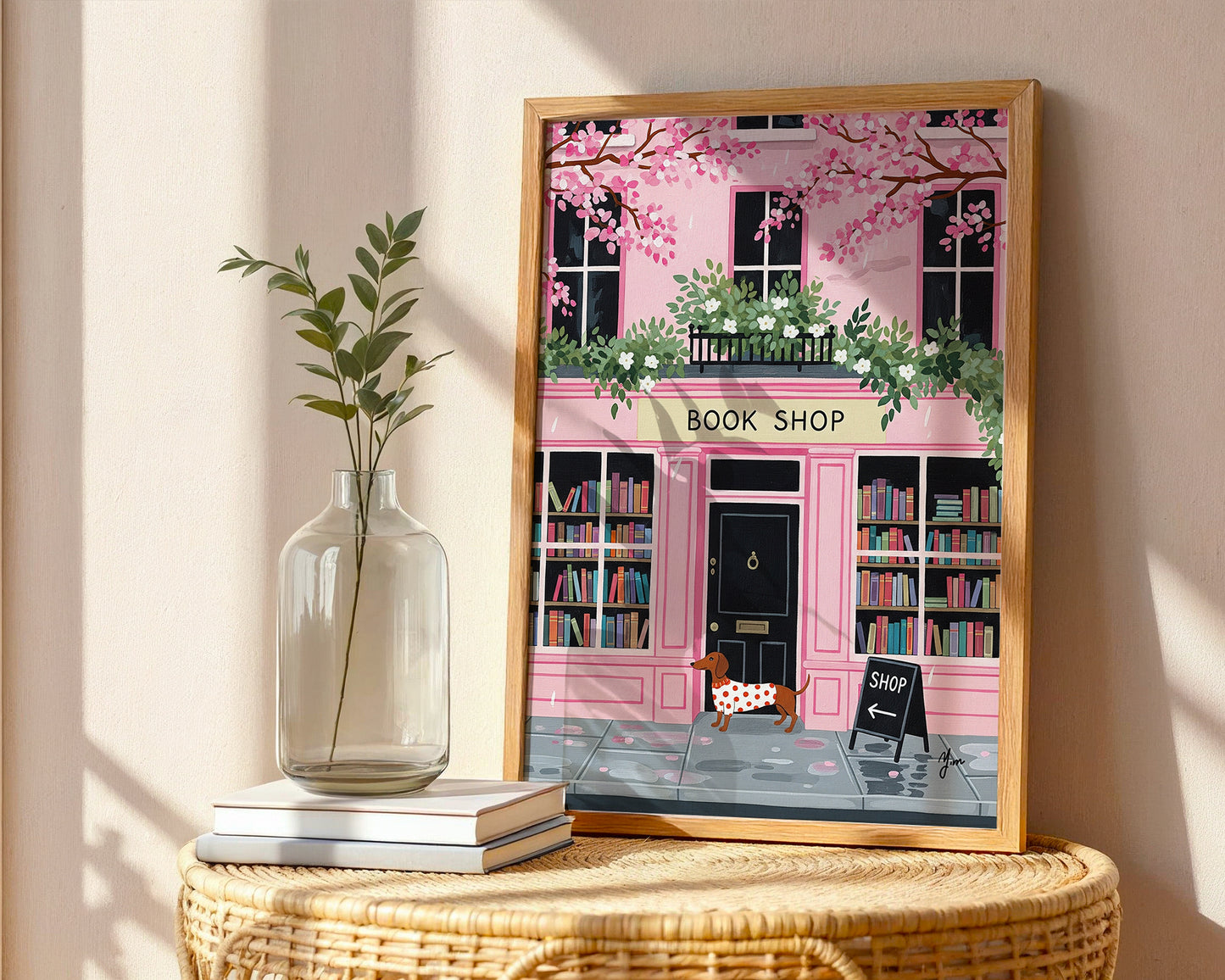 Dachshund in red polka dot sweater standing in front of pink bookshop with cherry blossoms and books